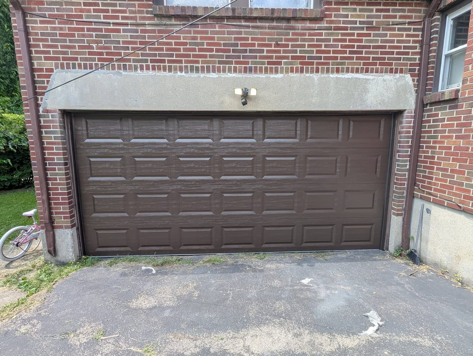 Finished brown garage door in the same brick opening